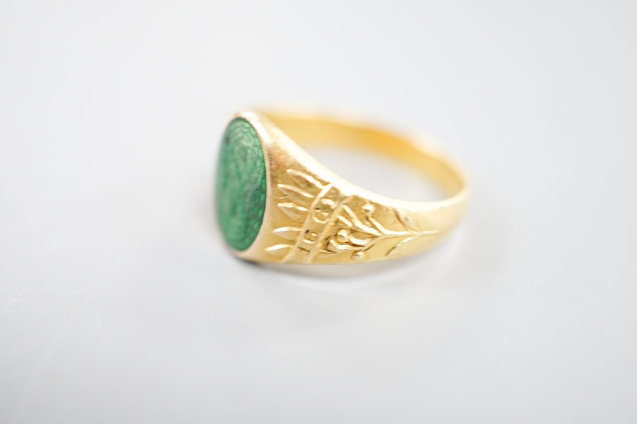 An early 20th century Austro-Hungarian (Vienna) 580/1000 yellow metal and green enamel signet ring, depicting the bust of a gentleman to sinister, size Q/R, gross 6.7 grams.